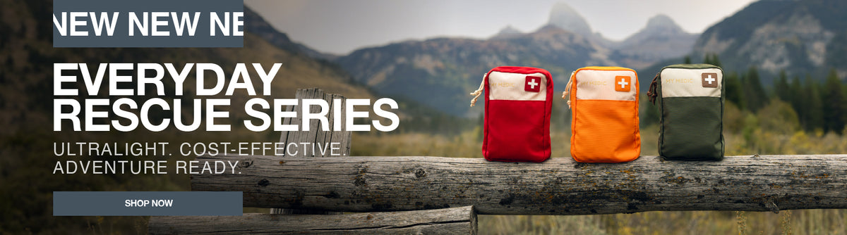 Three small emergency rescue pouches in red, orange, and olive green are displayed on a weathered wooden log outdoors, with mountains in the background. Large text on the left reads 'NEW NEW NE EVERYDAY RESCUE SERIES' and 'SHOP NOW'.