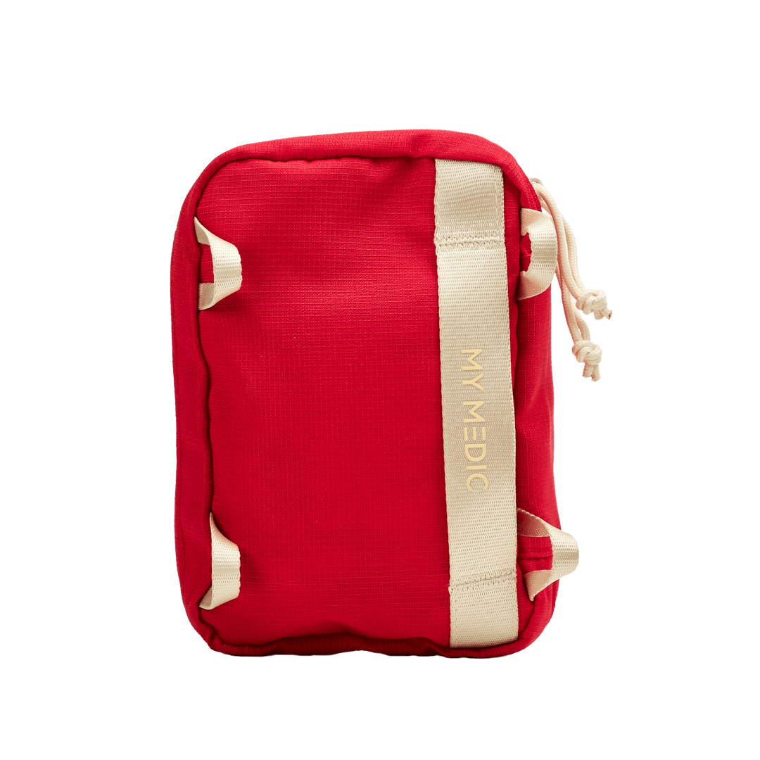 A red rectangular pouch with a vertical cream-colored strap featuring the brand name 'MY MEDIC' in gold lettering. The pouch has reinforced corners and a drawstring closure, shown against a plain white background.