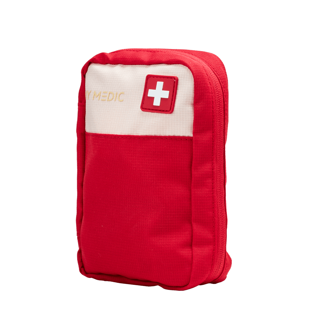 A red first aid pouch with a white top panel, featuring a white cross on a red square and the text 'MY MEDIC' in gold, set against a plain white background.