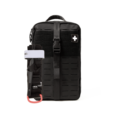 A black tactical first aid pouch with a vertical buckle strap, a side pocket holding a black tourniquet with a white band, and a white cross patch on the front, shown against a plain white background.
