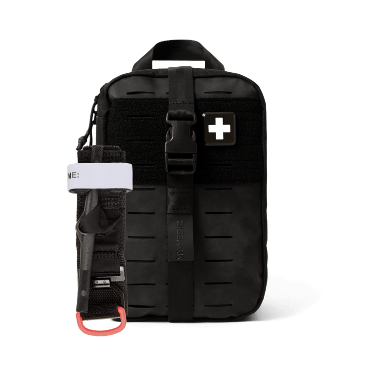 A black tactical first aid kit pouch with a front buckle strap and a white cross patch, shown on a clean white background. A black tourniquet