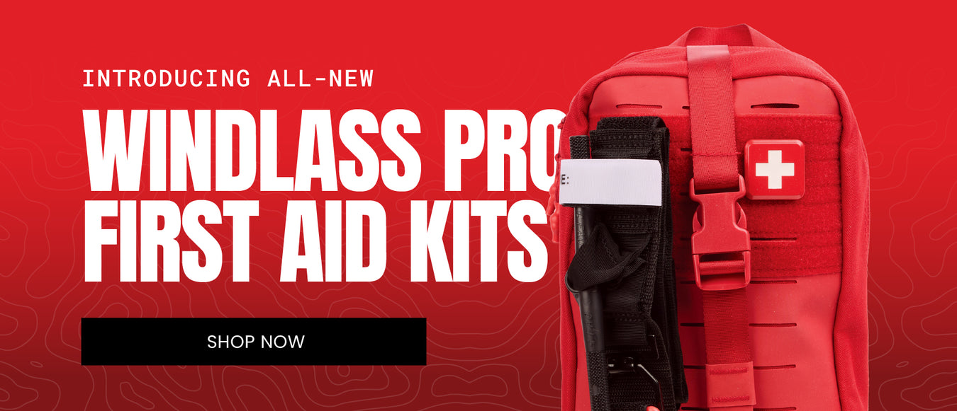 Red promotional banner for Windlass Pro First Aid Kits, showing a red backpack with a black first aid pouch and a white cross patch, alongside large white text reading 'INTRODUCING ALL-NEW WINDLLASS PRO FIRST AID KITS' and a black 'SHOP NOW' button.