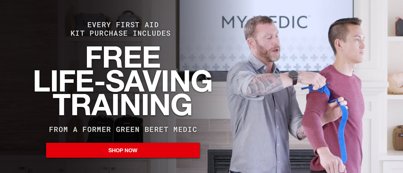 Promotional banner for a first aid kit purchase, featuring a man demonstrating first aid training to another man in a home setting. Large text reads 'FREE LIFE-SAVING TRAINING' with a red 'SHOP NOW' button.
