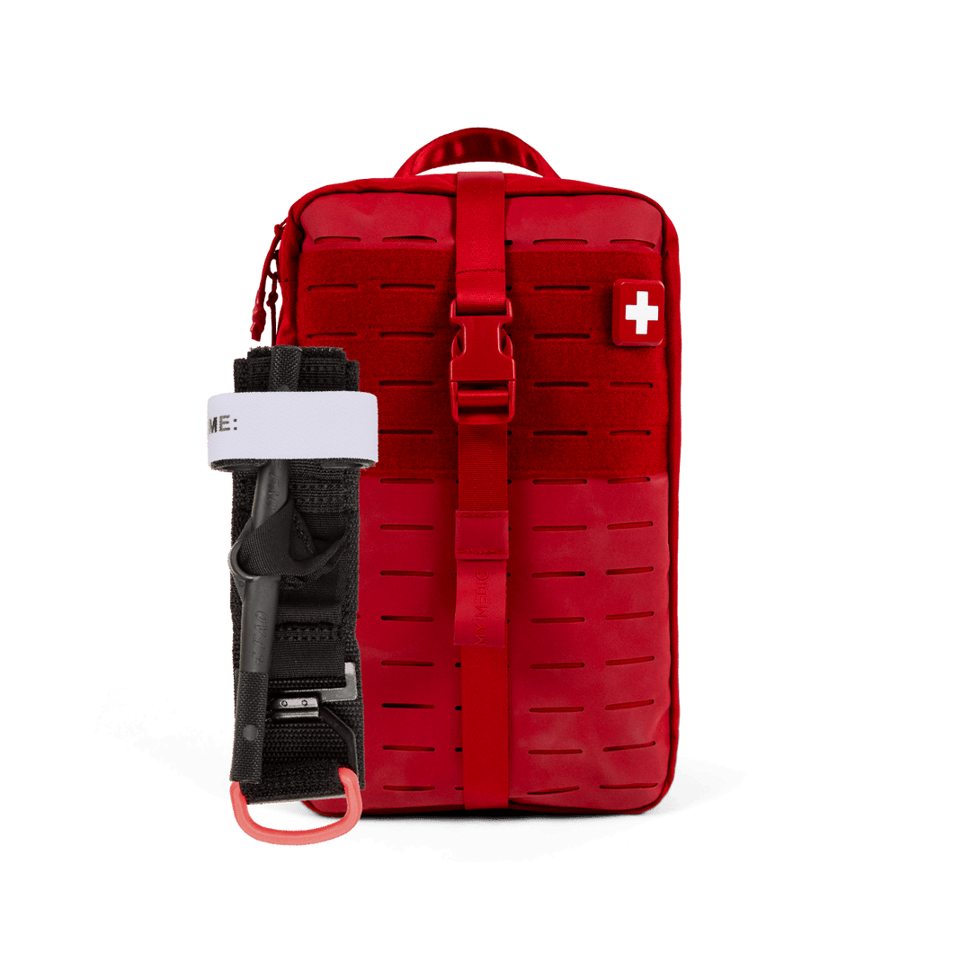 A red tactical first aid kit pouch with a quick-release buckle and a white cross symbol on the front, shown alongside a black and white tourniquet on a solid white background.
