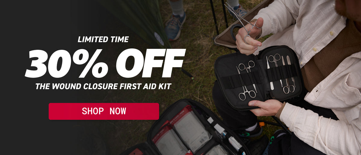 A promotional banner for a wound closure first aid kit showing a person holding an open black kit with surgical tools, alongside another kit on the ground. Large text on the left reads 'LIMITED TIME 30% OFF THE WOUND CLOSURE FIRST AID KIT' with a red 'SHOP NOW' button.